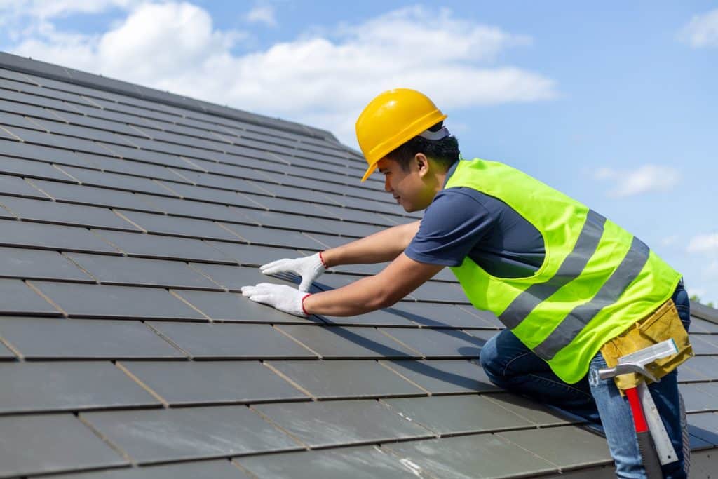 worker replacing gray tiles