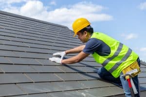 worker replacing gray tiles